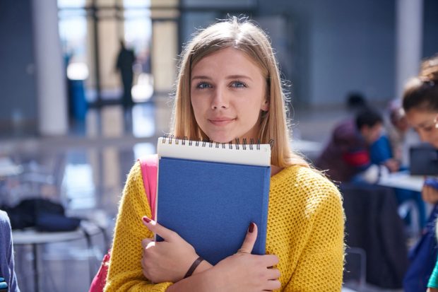 Female student holds notepad.