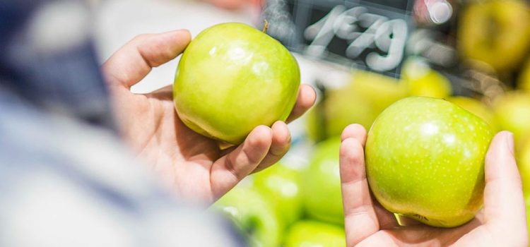 A person holding an apple in each hand