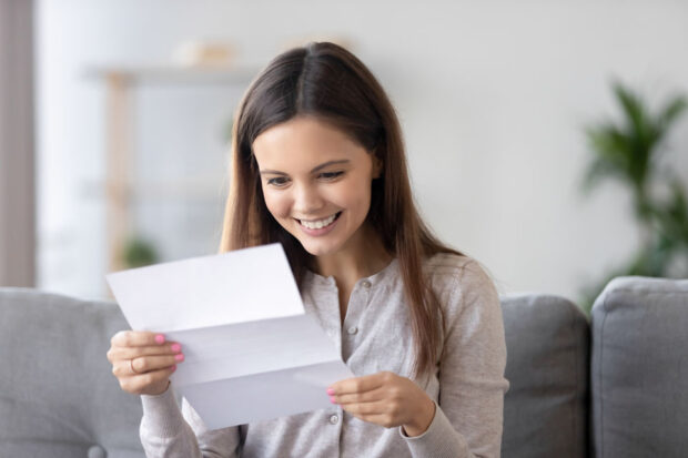 A female student looking at her exam results and smiling