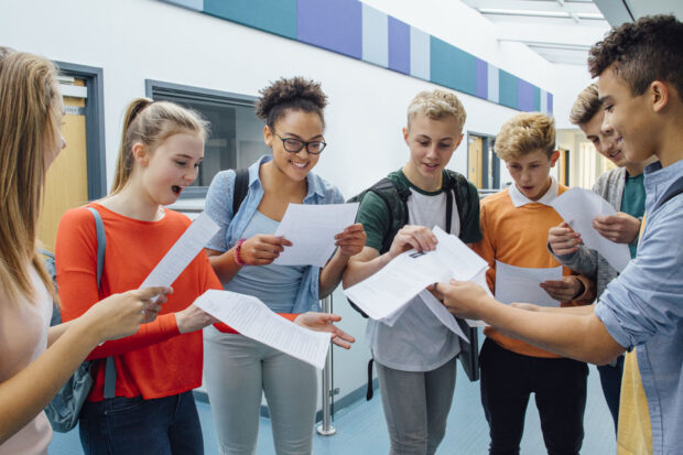 A group of students looking happy after receiving their exam results.